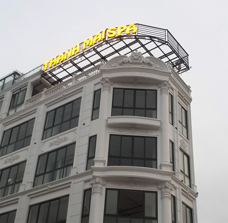 Biển quảng cáo chữ mica vàng gương đặt tại mặt trước của tòa nhà